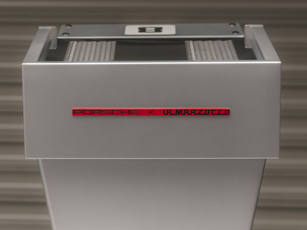 A Porsche x La Marzocco logo on the back of an espresso machine.