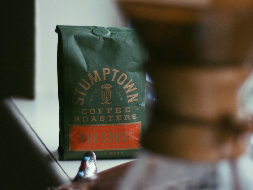 A bag of Hairbender specialty coffee next to a Chemex.