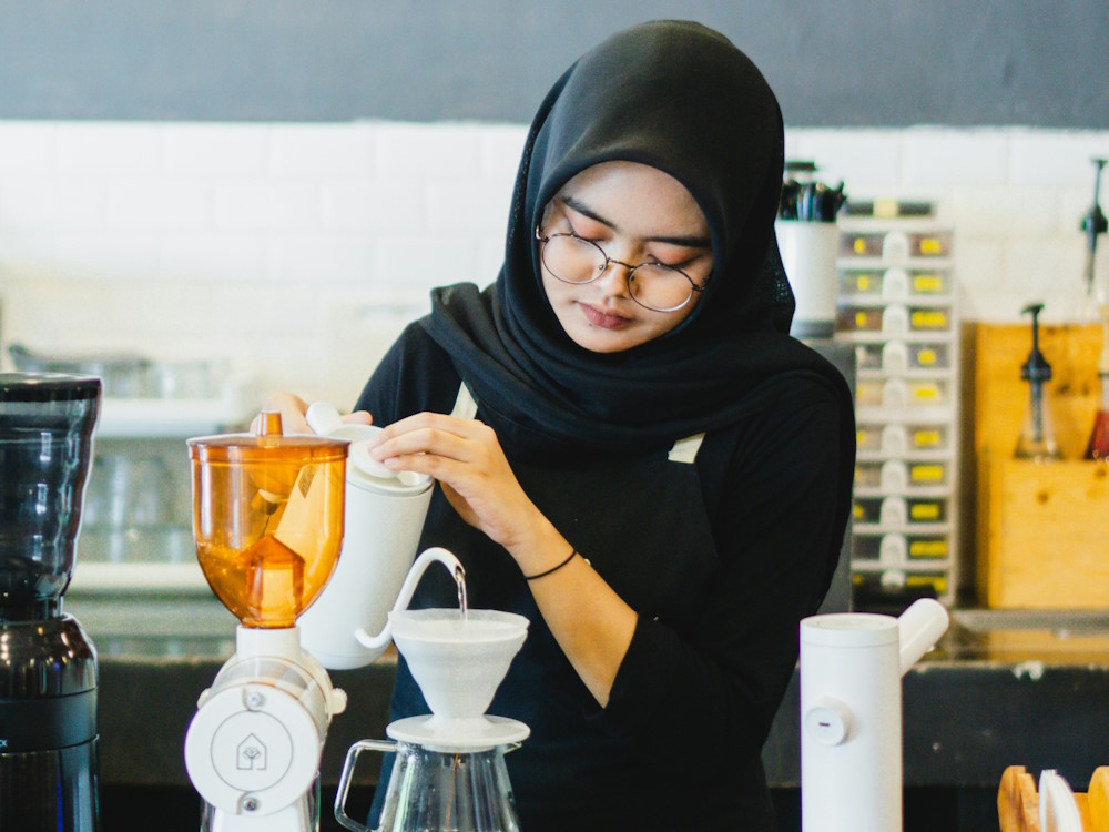 A female barista prepares a V60.