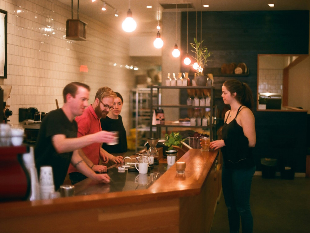 Several baristas behind the bar at Matchstick Coffee in Vancouver BC, Canada.