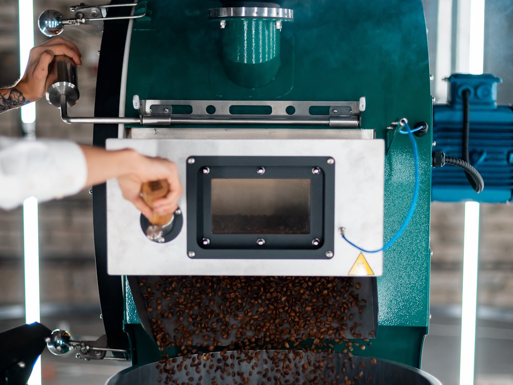 A roaster unloads a batch of coffee from a Typhoon machine.