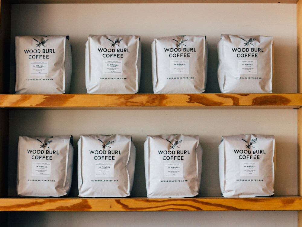 Bags of Wood Burl Coffee on shelves.