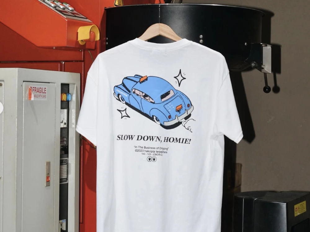 A t-shirt hangs on a machine in a roastery.