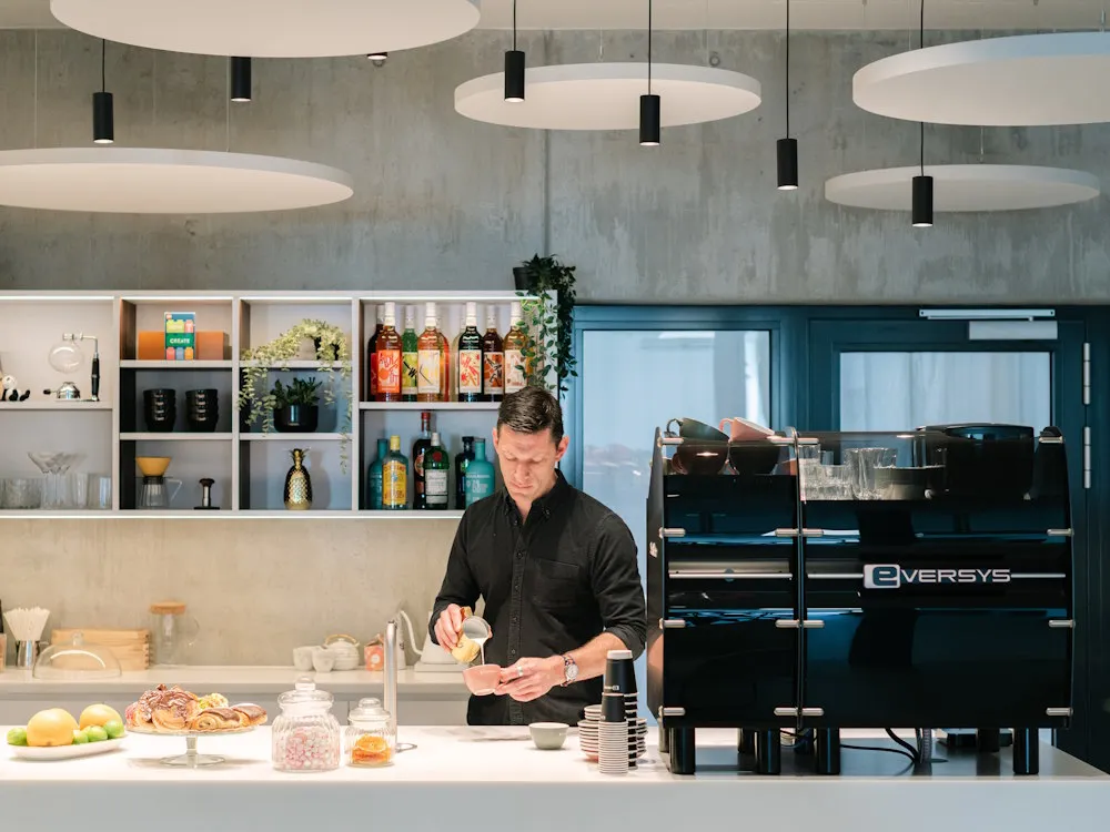 Dale Harris prepares coffee drinks behind a bar.